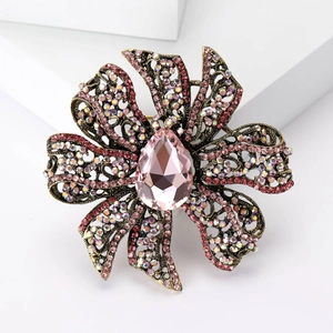Macro detail of vintage hollow flower brooch with pink crystals and gold-tone finish