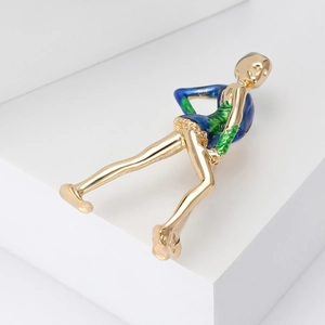 Macro detail of elegant golden gymnast brooch with blue and green enamel finish