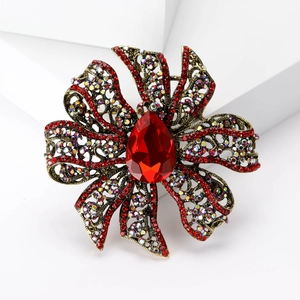 Vintage style hollow flower brooch with large red teardrop gemstone and sparkling rhinestones