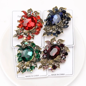 Detail of vintage style crystal brooches in four colors on a white display card