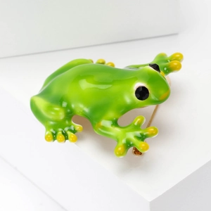 Elegante spilla a forma di rana in smalto verde con occhi in pietra nera su display