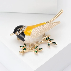 Broche oiseau en émail sur branche dorée avec plumes jaunes et zircons brillants