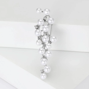 Detail of silver pearl brooch featuring clustered white pearls and sparkling rhinestones