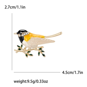 Broche oiseau en émail tendance avec cristaux et pierres vertes sur branche dorée