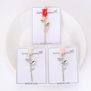 Vue détaillée des broches fleur de magnolia en émail rouge, blanc et rose