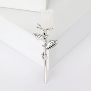Broche rose argentée élégante avec pétales de magnolia blancs sur fond blanc épuré