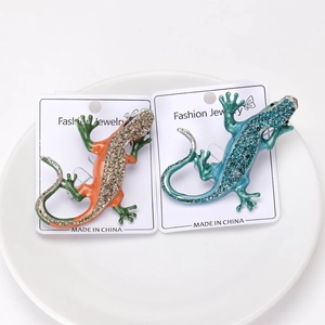 Macro detail of enamel lizard brooches with sparkling rhinestones on display card