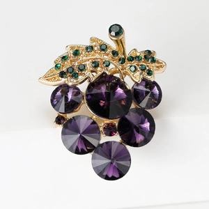 Detailed close-up of grape-shaped brooch with purple crystals and green rhinestones