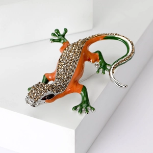 Detail of vintage lizard brooch with brown rhinestones and colorful enamel on white stand