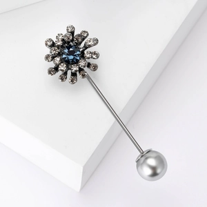 Detailed macro of vintage silver brooch pin with blue crystal and a pearl end