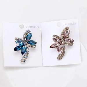 Dettaglio ravvicinato della spilla a fiocco con strass colorati e intarsio di zirconi