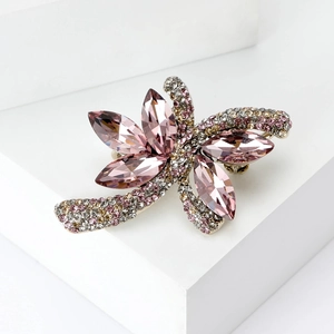 Dettaglio macro dei cristalli rosa marquise e pavé di strass sulla spilla da donna