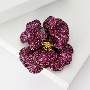 Detailed close-up of a pink zircon camellia flower brooch with dark nickel finish