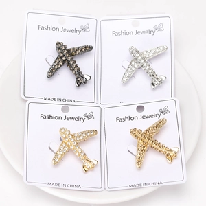 Détail de quatre broches avion en cristal finitions dorées, argentées et noires