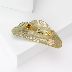 Broche nuage en émail doré avec texture radiale et fermoir épingle sur fond blanc