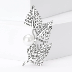 Close-up of silver leaf brooch with sparkling crystals and a large white pearl