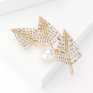 Elegant gold leaf brooch with white pearl and sparkling crystals on white background