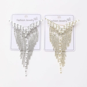 Detailed macro view of luxury silver and gold tassel brooches with sparkling rhinestones