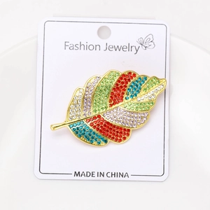 Gros plan de strass colorés sur une broche en forme de feuille en alliage doré