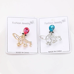 Detailansicht der Strass-Oktopus-Broschen in Gold mit roten und Silber mit blauen Kristallen