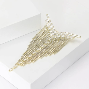 Detail view of luxury gold fringe brooch with sparkling rhinestones and long tassel chains