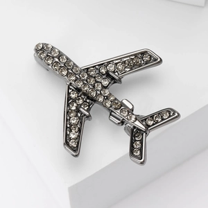 Gros plan détaillé d'une broche avion élégante ornée de strass sur un métal sombre