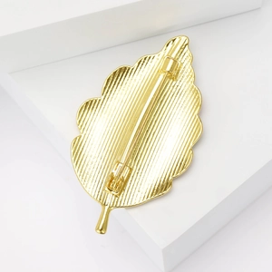 Vue arrière de l'élégante broche feuille dorée avec surface texturée et fermoir de sécurité