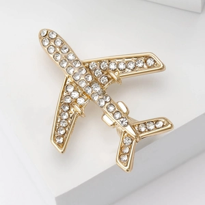Gros plan d'une broche avion dorée ornée de strass étincelants et de détails métalliques