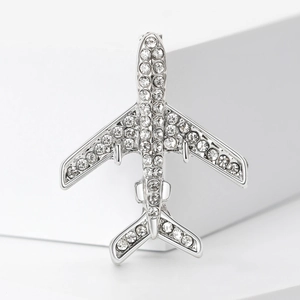 Broche avion argentée à la mode avec strass étincelants sur des blocs blancs minimalistes