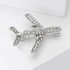 Détail macro de la broche avion argentée avec strass scintillants et fermoir de sécurité