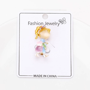 Détail d'une broche fillette avec émail coloré et accents nacrés sur carte Fashion