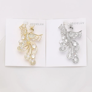 Detailed close-up of luxury phoenix brooches with cubic zirconia on white card