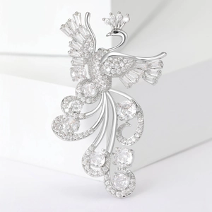 Macro shot of silver phoenix brooch with sparkling cubic zirconia on a white stand