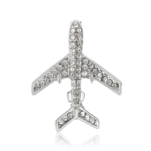 Élégante broche avion en argent avec des strass blancs sur fond blanc épuré