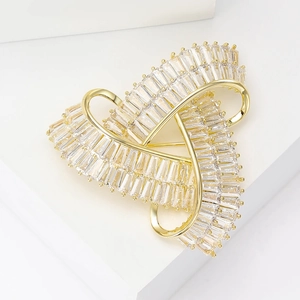 Vue détaillée d'une broche géométrique de luxe en finition dorée et oxydes de zirconium