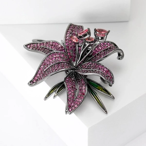 Gros plan détaillé d'une broche florale avec zircons roses et feuilles en émail vert