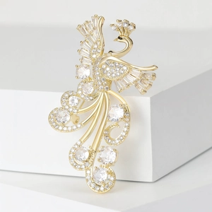 Macro detail of luxury gold phoenix brooch with shimmering cubic zirconia inlay