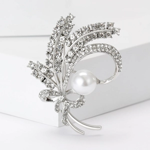 Macro shot of silver wheat ear brooch featuring crystal rhinestones and a white pearl