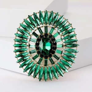 Macro detail of luxury emerald green oval crystal brooch with multi-layer rhinestone settings