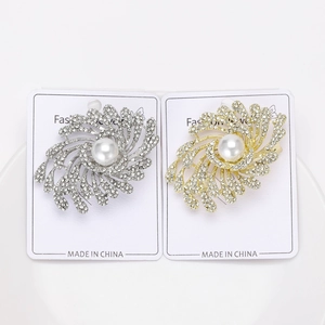 Macro detail of elegant silver and gold fireworks brooches with pearls and rhinestones