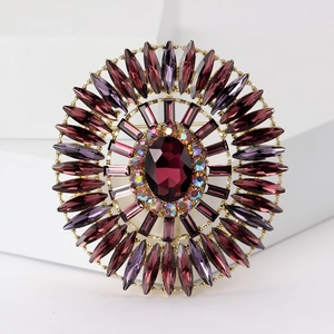 Macro detail of large oval purple crystal brooch with radiant gemstone arrangement