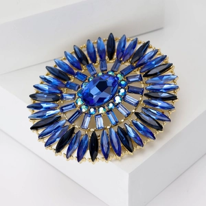 Detailed macro view of luxury oval blue crystal brooch with vintage gold setting