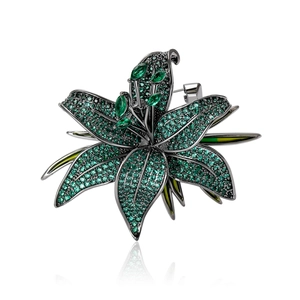 Élégante broche fleur de lys avec zircons vert émeraude sur base plaquée noire