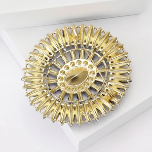Back view of luxury oval crystal brooch showing gold radial texture and pin closure