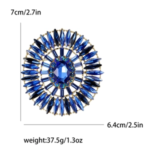 Luxurious sunburst brooch with large oval blue crystal and gold-plated metal base