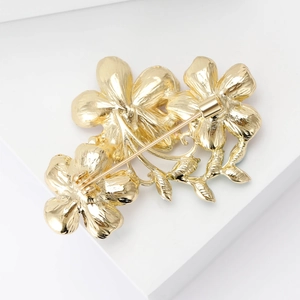 Detailed rear view of the golden triple camellia flower brooch showing sturdy safety pin