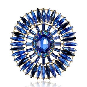 Luxurious gold-plated sunburst brooch with a large blue oval crystal and rhinestones