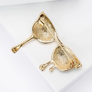 Macro shot of the textured gold metal back and secure safety pin clasp of the brooch