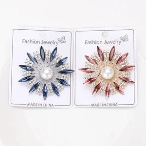 Close-up of elegant flower brooches with rhinestones and pearls on display cards