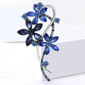 Gros plan sur une broche fleur de luxe avec strass bleus sur base en alliage